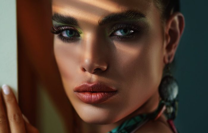 crop stylish model with makeup near wall