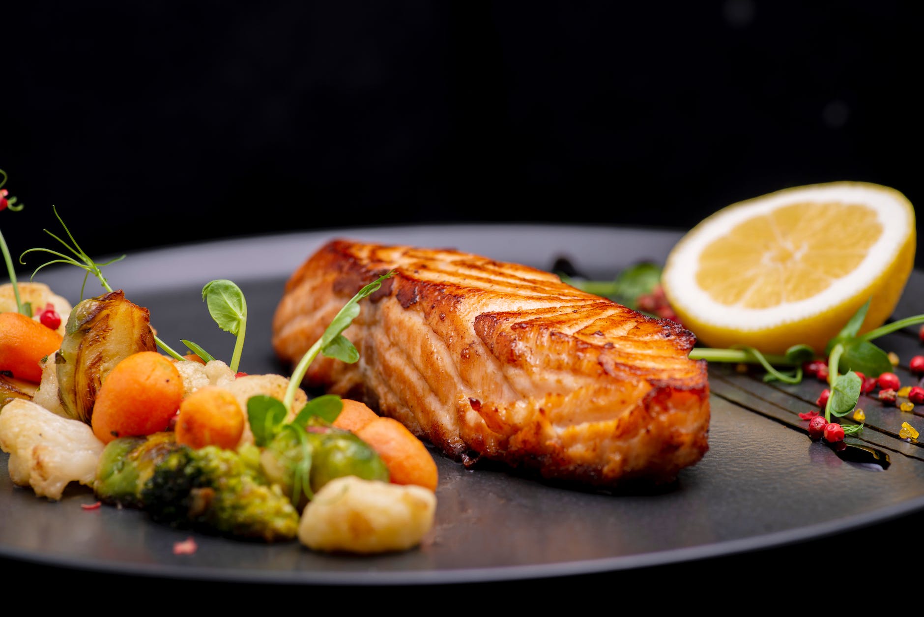 close up shot of delicious grilled salmon on black plate