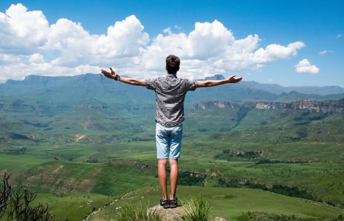 man wearing grey shirt standing on elevated surface