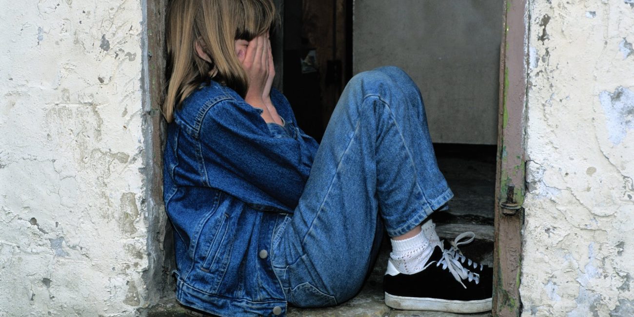 lonely girl sitting on a doorway