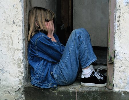 lonely girl sitting on a doorway