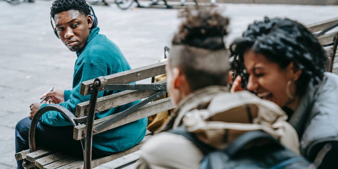 couple of students gossiping and laughing near black man