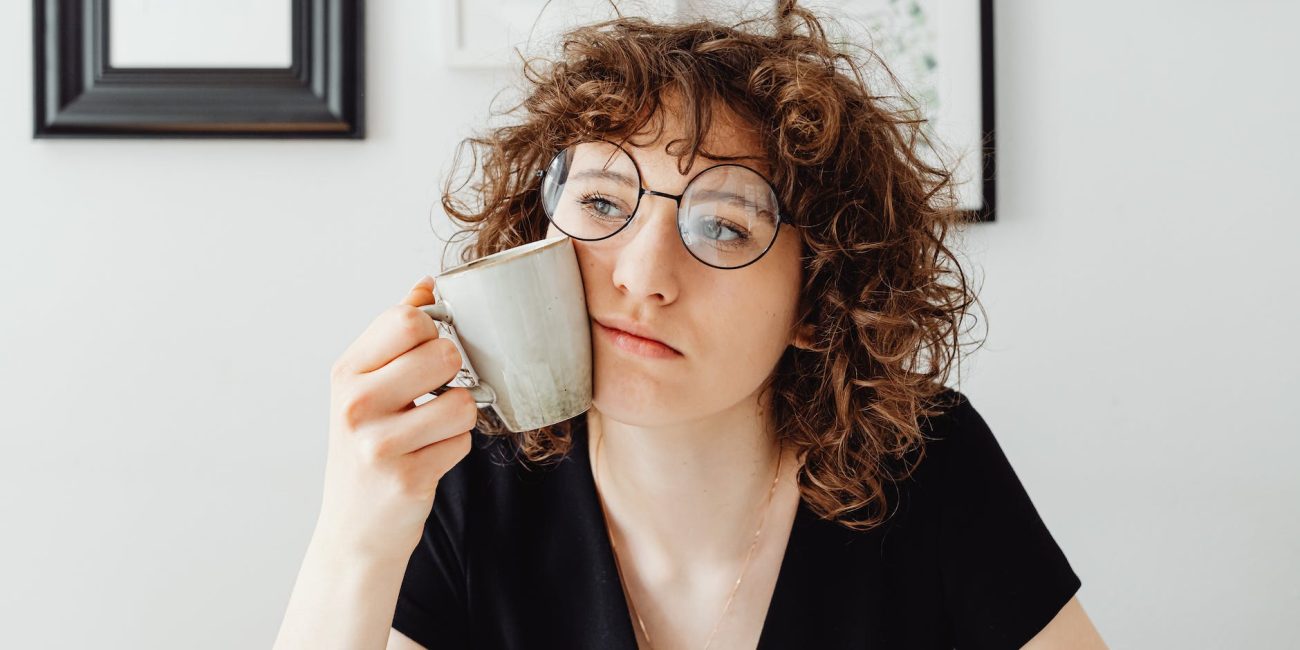 curly haired woman holding a coffee mug