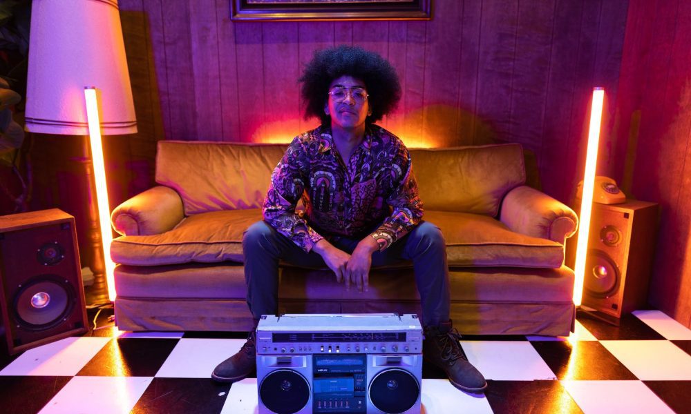 a boombox in front of a man sitting on the couch