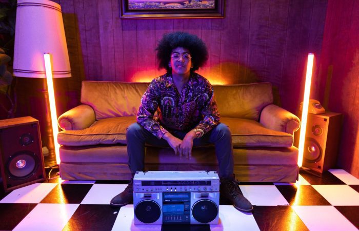 a boombox in front of a man sitting on the couch