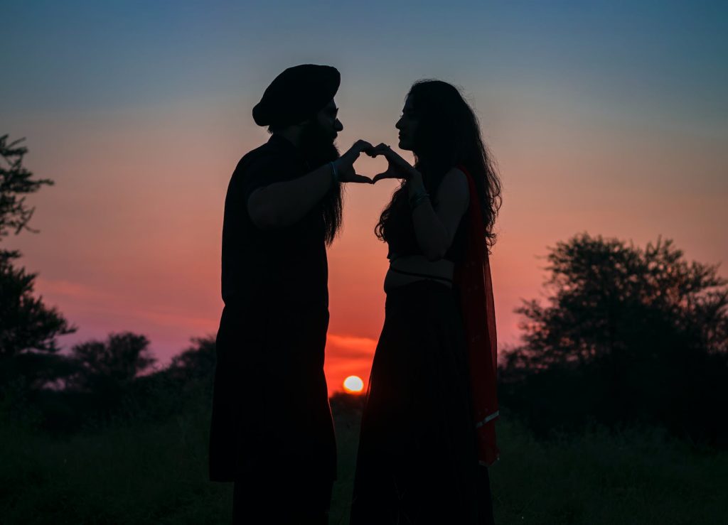 silhouette photo of couple making a heart shape