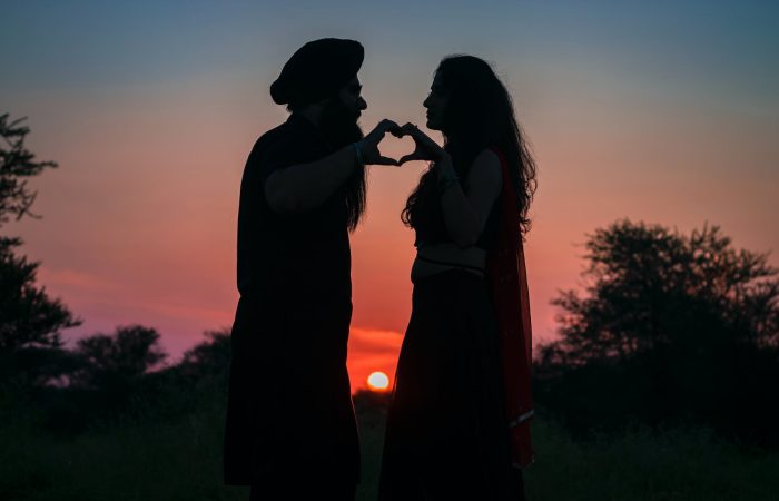silhouette photo of couple making a heart shape
