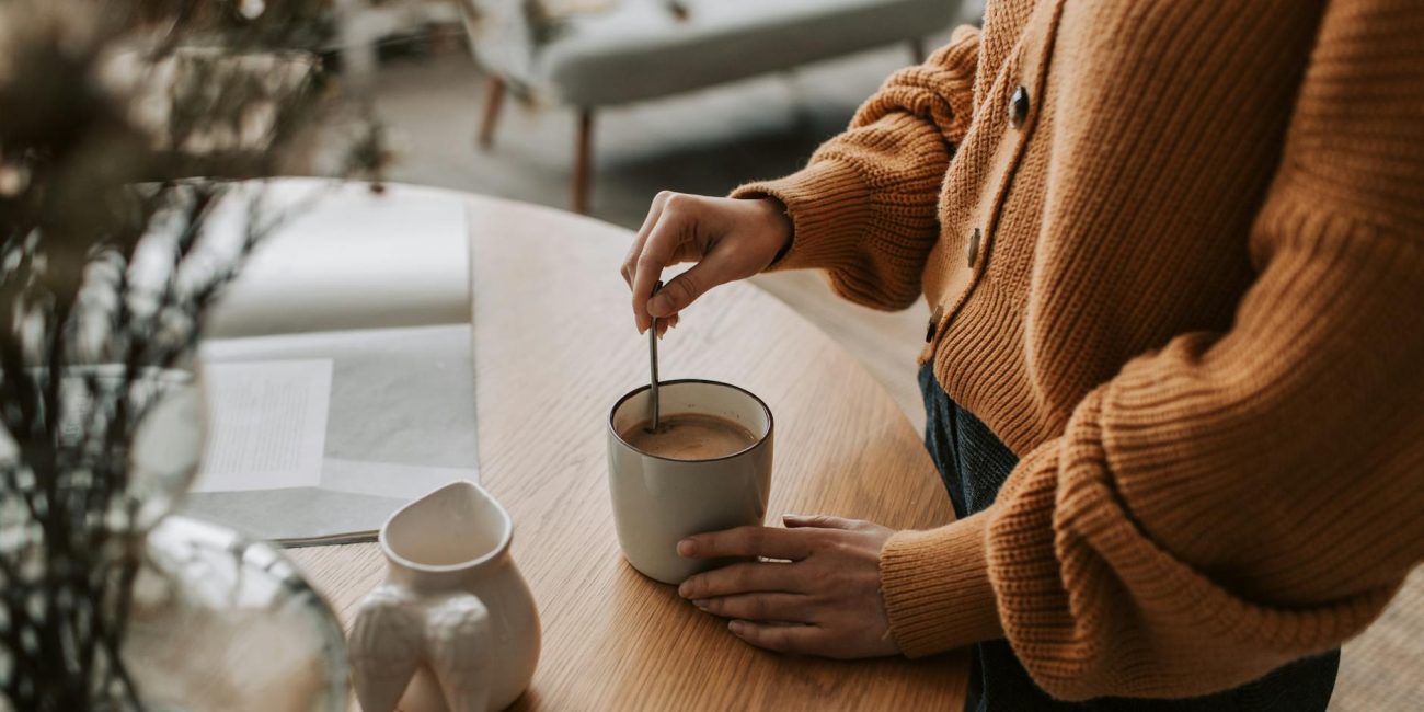 a person mixing a drink in a mug