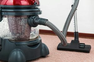 black and red canister vacuum cleaner on floor