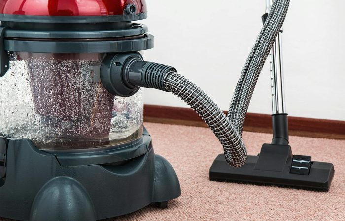 black and red canister vacuum cleaner on floor