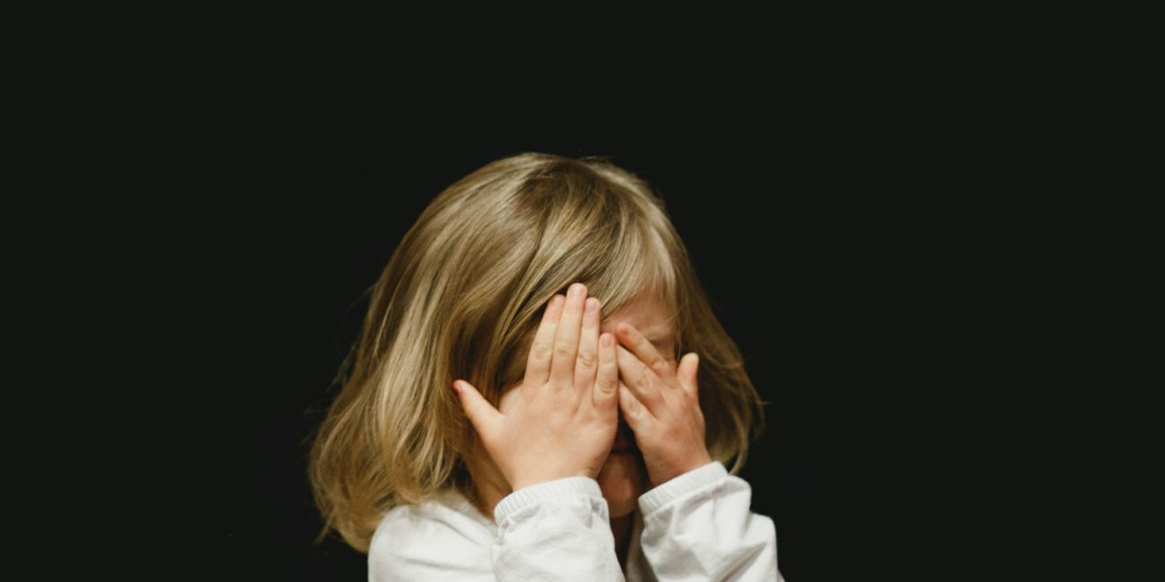 girl covering her face with both hands